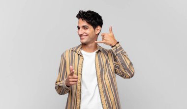 Genç yakışıklı adam neşeyle gülümsüyor ve kamerayı işaret ediyor. Sonra seni arıyor, telefonla konuşuyor.