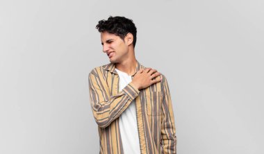 Genç yakışıklı adam yorgun, stresli, endişeli, hayal kırıklığına uğramış ve depresyonda, sırtı ya da boynu ağrıyan