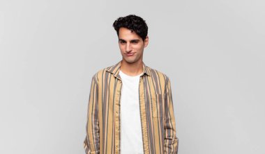 Genç yakışıklı, gururlu, kendinden emin, havalı, küstah, küstah, gülümseyen, başarılı hisseden bir adam.