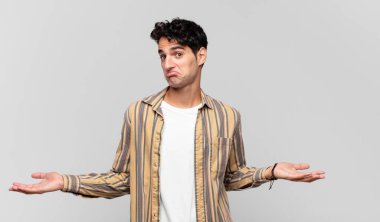 Genç yakışıklı bir adam bilgisiz ve kafası karışık, hiçbir fikri yok, aptal ya da aptal bir bakışla tamamen kafası karışmış.