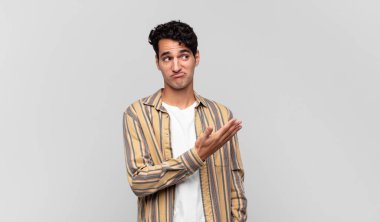 Genç yakışıklı bir adam kafası karışık ve bilgisiz, şüpheli bir açıklama ya da düşünceyi merak ediyor.