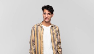 Genç yakışıklı adam korkmuş ve şok olmuş hissediyor, ağzı açık şaşkınlık içinde.