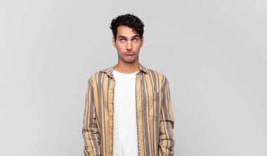 Genç ve yakışıklı adam şapşal ve komik görünüyor. Şaşı bakışlı, şakacı ve şakacı.