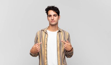 Genç yakışıklı adam gururlu, pozitif ve iki eliyle göğsünü gösteren