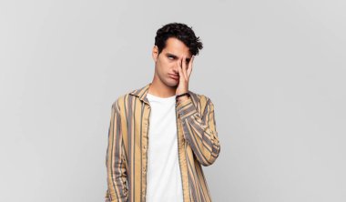 Genç ve yakışıklı bir adam yorgun, sıkıcı ve sıkıcı bir işin ardından sıkılmış, hayal kırıklığına uğramış ve uykulu hisseder.