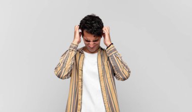 Genç ve yakışıklı bir adam stresli ve hayal kırıklığına uğramış hissediyor. Yumruk yumruğa, yorgun, mutsuz ve migren ağrısı çekiyor.