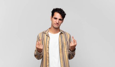 Genç yakışıklı adam kışkırtıcı, agresif ve müstehcen hissediyor. İsyankar bir tavırla orta parmağını hareket ettiriyor.