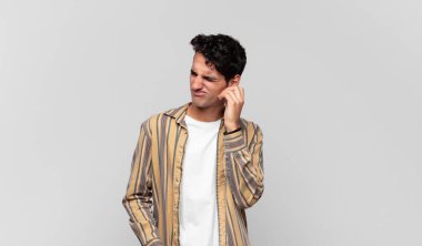 Genç ve yakışıklı bir adam stresli, hayal kırıklığına uğramış ve yorgun, endişeli ve sorunlu bir bakışla boynunu okşuyor.