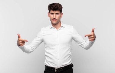 Genç yakışıklı adam gururlu, kibirli, mutlu, şaşırmış ve tatmin olmuş görünüyor, kendini gösteriyor, kazanan gibi hissediyor.