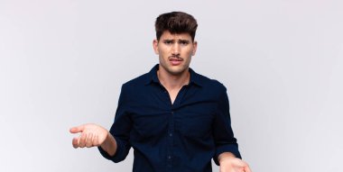 Genç yakışıklı bir adam bilgisiz ve kafası karışık, hangi seçeneği seçeceğinden emin değil, merak ediyor.