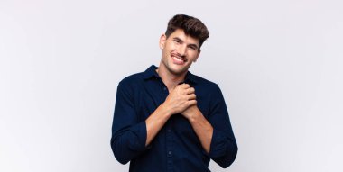 Genç, yakışıklı bir adam aşık ve sevimli görünüyor. Sevimli ve mutlu. Romantik bir şekilde gülümsüyor.