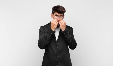 Genç yakışıklı adam endişeli, endişeli, stresli ve korkmuş görünüyor, tırnaklarını yiyor ve yanal fotokopi alanı arıyor.