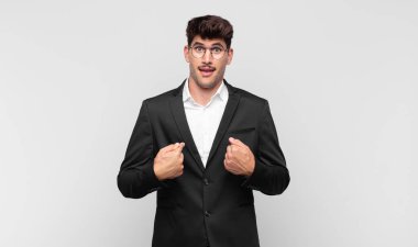 Genç yakışıklı adam mutlu, şaşkın ve gururlu, heyecanlı, şaşkın bakışlarıyla kendini işaret ediyor.