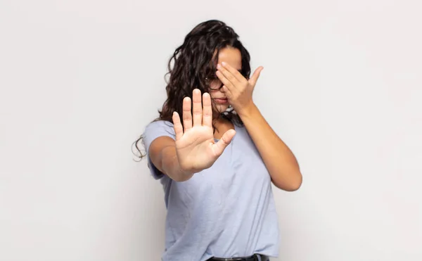 Ładna Młoda Kobieta Zakrywając Twarz Ręką Kładąc Drugą Rękę Przodu — Zdjęcie stockowe
