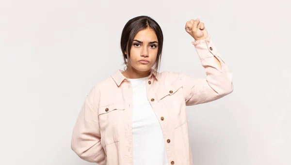 かなり若い女性は深刻さを感じ 強く反抗的で 拳を上げ 革命のために抗議したり戦ったり — ストック写真