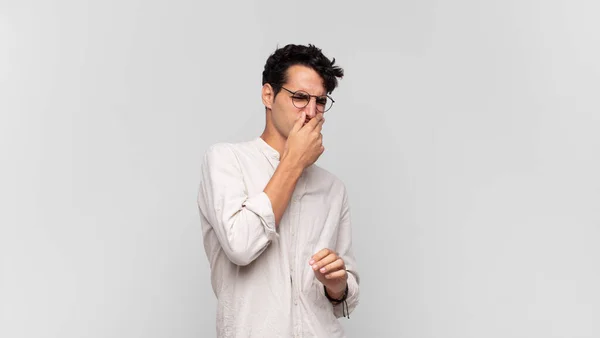 Jovem Homem Bonito Sentindo Enojado Segurando Nariz Para Evitar Cheirar — Fotografia de Stock