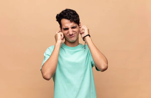 Joven Hombre Guapo Mirando Enojado Estresado Molesto Cubriendo Ambos Oídos — Foto de Stock