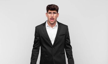 Genç yakışıklı adam korkmuş ve şok olmuş hissediyor, ağzı açık şaşkınlık içinde.