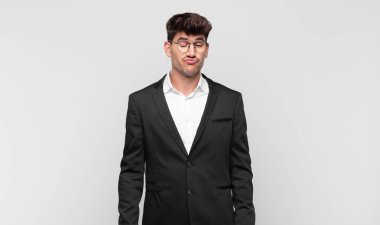 Genç ve yakışıklı adam şapşal ve komik görünüyor. Şaşı bakışlı, şakacı ve şakacı.