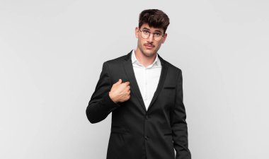 Kafası karışmış, kafası karışmış ve kendine güveni olmayan genç yakışıklı bir adam kendini göstererek kim olduğunu soruyor, ben mi??