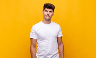 Genç yakışıklı, gururlu, kendinden emin, havalı, küstah, küstah, gülümseyen, başarılı hisseden bir adam.