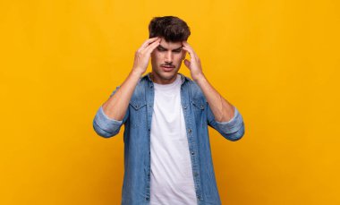 Genç ve yakışıklı bir adam stresli ve hayal kırıklığına uğramış görünüyor. Baskı altında çalışıyor ve sorunları var.