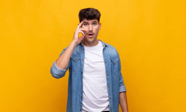 Genç yakışıklı adam şaşırmış, ağzı açık, şok olmuş, yeni bir düşünce, fikir ya da konsept keşfediyor.