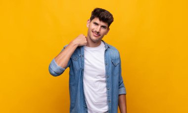 Genç ve yakışıklı bir adam neşeli ve kendinden emin bir şekilde gülüyor. Sıradan, mutlu, samimi bir gülümsemeyle.