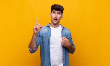 Genç yakışıklı adam gururlu ve şaşırmış, kendine güvenen, kendini bir numara gibi hisseden.