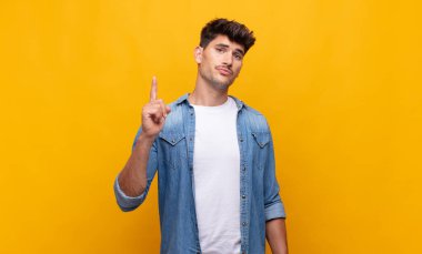 Genç yakışıklı bir adam, harika bir fikri fark ettikten sonra parmağını havaya kaldırıp 