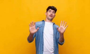 Genç yakışıklı adam sersemlemiş ve korkmuş hissediyor. Korkutucu bir şeyden korkuyor. Elleri açık ve uzak dur diyor.