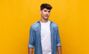 Genç yakışıklı, kafası karışık ve şüpheli hissediyor, merak ediyor ya da karar vermeye çalışıyor.