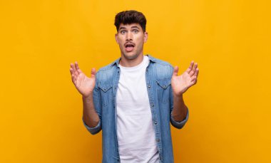 Genç ve yakışıklı bir adam beklenmedik bir sürpriz yüzünden şaşkın ve heyecanlı, güler yüzlü, şaşkın ve mutlu hissediyor.