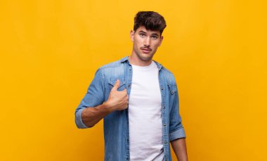 Kafası karışmış, kafası karışmış ve kendine güveni olmayan genç yakışıklı bir adam kendini göstererek kim olduğunu soruyor, ben mi??