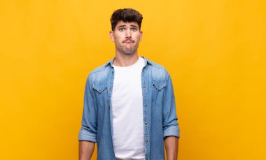 Genç yakışıklı adam üzgün ve stresli, kötü bir sürpriz yüzünden üzgün, olumsuz, endişeli bir bakışla