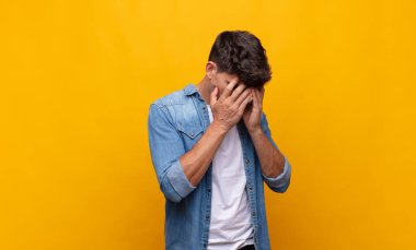 Genç yakışıklı adam üzgün, hayal kırıklığına uğramış bir bakışla gözlerini kapatıyor umutsuzluk, ağlama, yan bakış