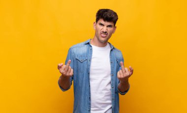 Genç yakışıklı adam kışkırtıcı, agresif ve müstehcen hissediyor. İsyankar bir tavırla orta parmağını hareket ettiriyor.