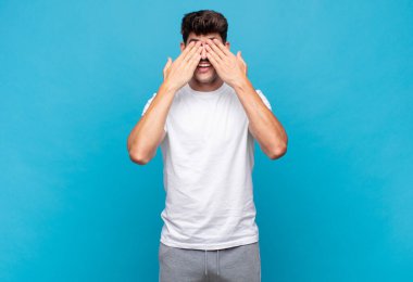 Genç yakışıklı adam gülümsüyor ve mutlu hissediyor, iki eliyle gözlerini kapatıyor ve inanılmaz bir sürpriz bekliyor.