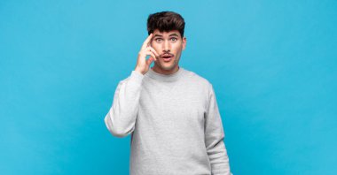 Genç yakışıklı adam şaşırmış, ağzı açık, şok olmuş, yeni bir düşünce, fikir ya da konsept keşfediyor.