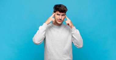 Genç yakışıklı bir adam konsantre olmuş ve bir fikir üzerinde kafa yoruyor, bir meydan okumaya ya da soruna bir çözüm hayal ediyor.