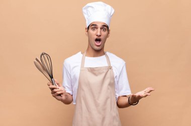 Genç fırıncı kendini çok şaşırmış, şaşırmış, endişeli ve paniklemiş hissediyor, stresli ve dehşete kapılmış bir bakışla