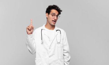 Genç doktor bir fikri fark ettikten sonra mutlu ve heyecanlı bir dahi gibi hissediyor, neşeli bir şekilde parmağını kaldırıyor, eureka!