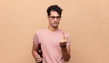 Bira içen genç adam kızgın, sinirli, isyankar ve agresif orta parmağını sallayarak karşılık veriyor.