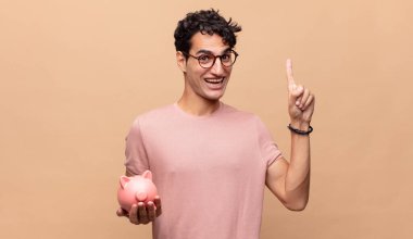 Kumbarası olan genç bir adam bir fikri fark ettikten sonra mutlu ve heyecanlı bir dahi gibi hissediyor.!