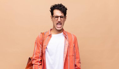 Genç öğrenci agresif bir şekilde bağırıyor, kızgın, sinirli, öfkeli ya da sinirli görünüyor, hayır