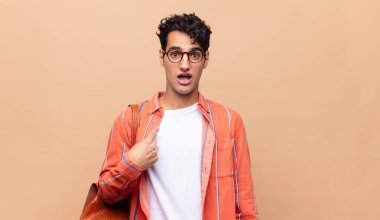 Şok olmuş ve ağzı açık, kendini işaret eden genç bir öğrenci.