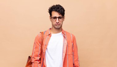 Genç bir öğrenci üzgün ve mızmızlanıyor, mutsuz bir bakışla, negatif ve hayal kırıklığına uğramış bir tavırla ağlıyor.