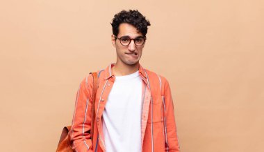 Genç öğrenci şaşkın ve şaşkın görünüyor. Sinirli bir hareketle dudağını ısırıyor. Sorunun cevabını bilmiyor.