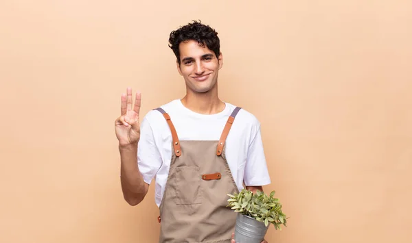 Jovem Jardineiro Homem Sorrindo Olhando Amigável Mostrando Número Dois Segundo — Fotografia de Stock