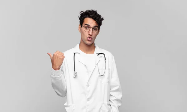 Giovane Medico Guardando Stupito Nella Incredulità Indicando Oggetto Sul Lato — Foto Stock